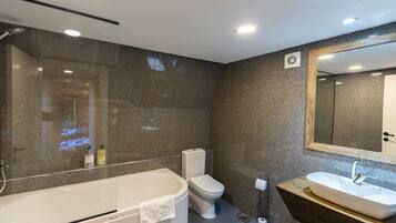 A modern bathroom with a freestanding bathtub, a toilet, and a vanity with a sink.