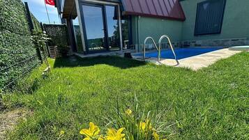 A residential property with a swimming pool, a glass-enclosed patio, and a flag.