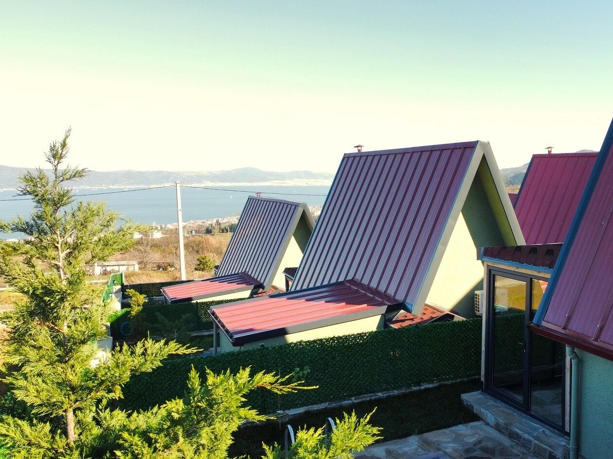Vista di una zona costiera con una fila di sdraio colorate e moderne e un edificio con tetto spiovente.