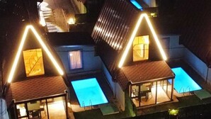 Ein Wohnkomplex mit mehreren Häusern, jedes mit einem Schwimmbecken und einer überdachten Terrasse.