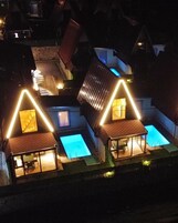 A residential complex with multiple houses, each featuring a swimming pool and a covered patio area.