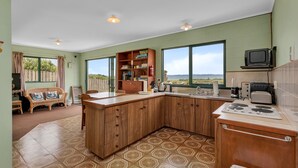 Una cocina amplia con armarios de madera, horno empotrado y un ventanal con vistas al exterior.
