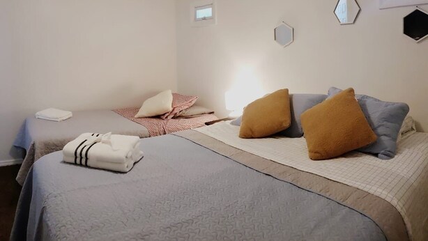 A bedroom with two beds, a window, and a small mirror on the wall. - Cozy Apartment in S Orlando, approx. 20 minutes away from Disney and Universal. (Orlando)