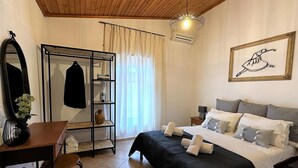 A bedroom with a bed, a desk, a chair, a wardrobe, a mirror, a hanging light fixture, and a framed picture on the wall. - Afroditi 4 bedrooms,pool,Picturesque village (Pigouniana)