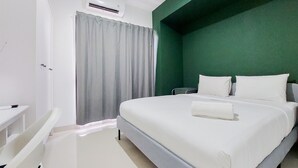 A hotel room with a bed, a desk, and a chair.