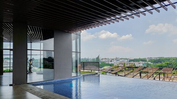 A modern indoor swimming pool with a clear view of the surrounding cityscape.