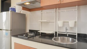 A kitchen with a stainless steel refrigerator, a gas stove, a sink, and white cabinets. - Comfortable And Homey 2Br Belmont Residence Puri Apartment (Jakarta)