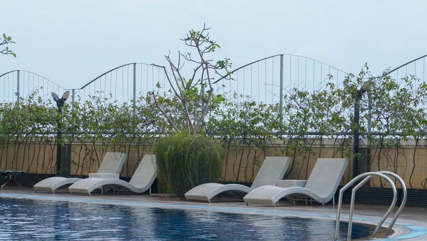 A pool area with lounge chairs and a metal ladder. - Comfortable And Homey 2Br Belmont Residence Puri Apartment (Jakarta)