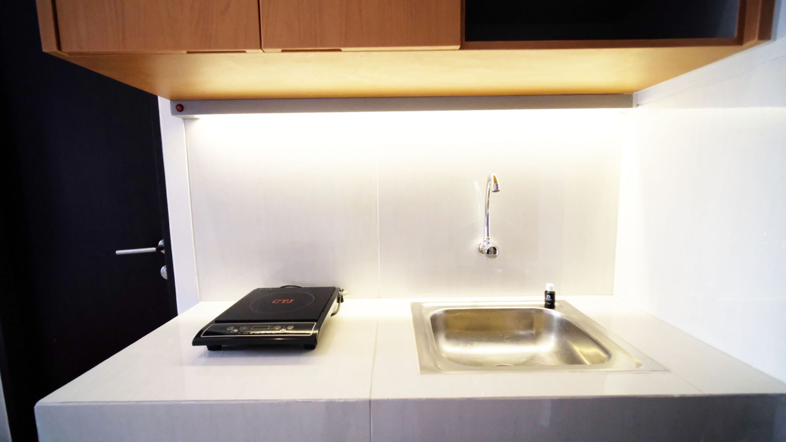 A kitchen with a countertop, a sink, and a black electronic device.
