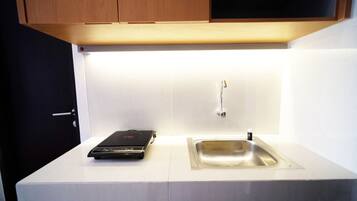 A kitchen with a countertop, a sink, and a black electronic device.