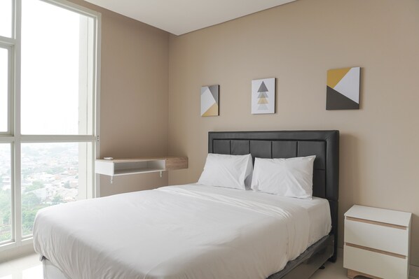 Ein Schlafzimmer mit einem Bett, einem Nachttisch, einem Fenster und Wandbildern.
