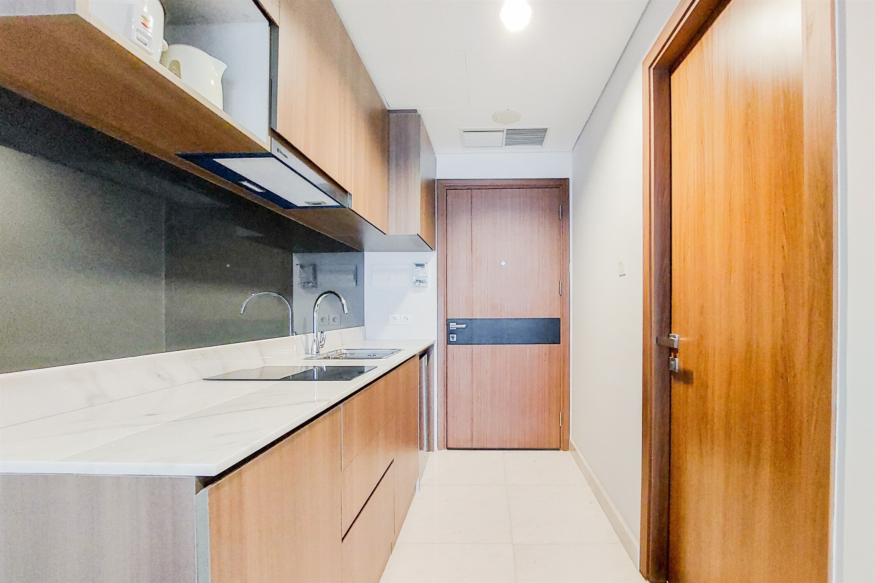 A modern kitchen with a marble countertop, stainless steel sink, and wooden cabinets.