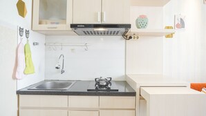 A modern kitchen with a gas stove, stainless steel sink, and wooden cabinets.