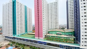 A high-rise residential building with multiple floors, a central courtyard, and a pedestrian bridge.