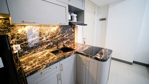 A kitchen with marble countertops, a sink, and modern cabinetry. - Compact And Homey 2Br At Benson Supermall Mansion Apartment (Surabaya)