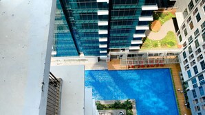 A rooftop swimming pool with a view of adjacent buildings. - Good Deal And Elegant Studio Tamansari Iswara Apartment (Bekasi)