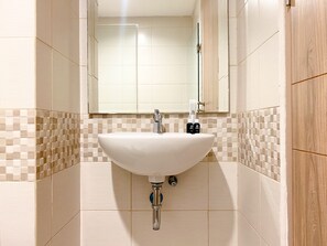 Bathroom features a central sink, mirror, and checkered tile wall.
