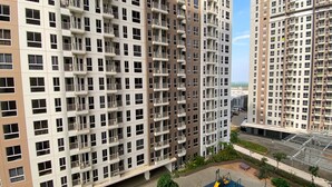 A high-rise residential building with multiple balconies, a playground, and a parking area. - Fully Furnished Studio At 11Th Floor Tokyo Riverside Pik 2 Apartment (Teluknaga)