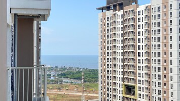 Um edifício alto com várias varandas e vista para o mar.