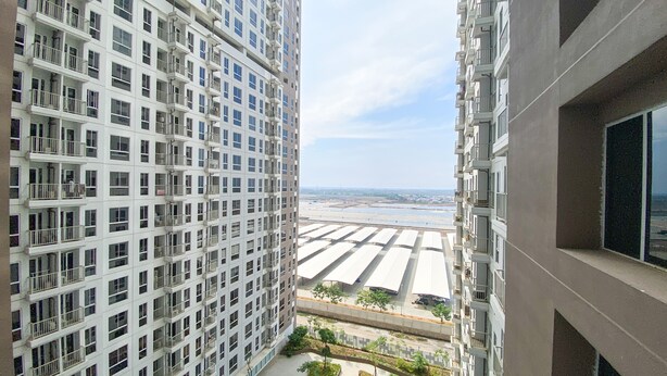 Um edifício alto com várias varandas e vista para a área à beira-mar.