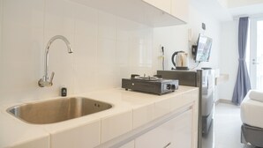 Una cocina moderna con un lavamanos de acero inoxidable, una estufa a gas y un refrigerador.