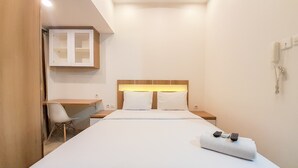 A hotel room with a bed, a desk, and a chair. - Relaxing Studio At Taman Melati Sinduadi Apartment (Pogung Lor)