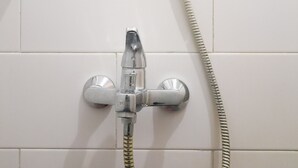A shower with a chrome faucet and a flexible hose. - Relaxing Studio At Taman Melati Sinduadi Apartment (Pogung Lor)