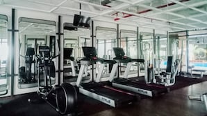 Ein Fitnessstudio mit Laufbändern, Kraftgeräten und Spiegeln.