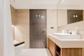 Une salle de bain moderne avec des toilettes, un lavabo et un miroir.