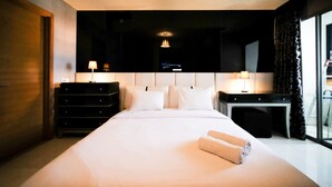 A hotel room with a large bed, two bedside tables with lamps, a dresser, and a TV mounted on the wall. - Spacious And Comfy 2Br Apartment At Aryaduta Residence Surabaya (Surabaya)