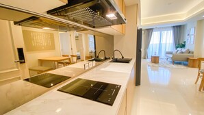 A modern kitchen with a central island, built-in oven, and a black range hood. - Best Deal And Strategic 2Br Marquis De Lafayette Apartment (Semarang)