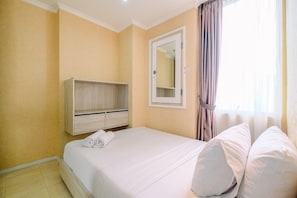 A hotel room with a bed, a wardrobe, a mirror, and a window with curtains. - Elegant And Comfort 2Br Apartment At Fx Residence (Jakarta)
