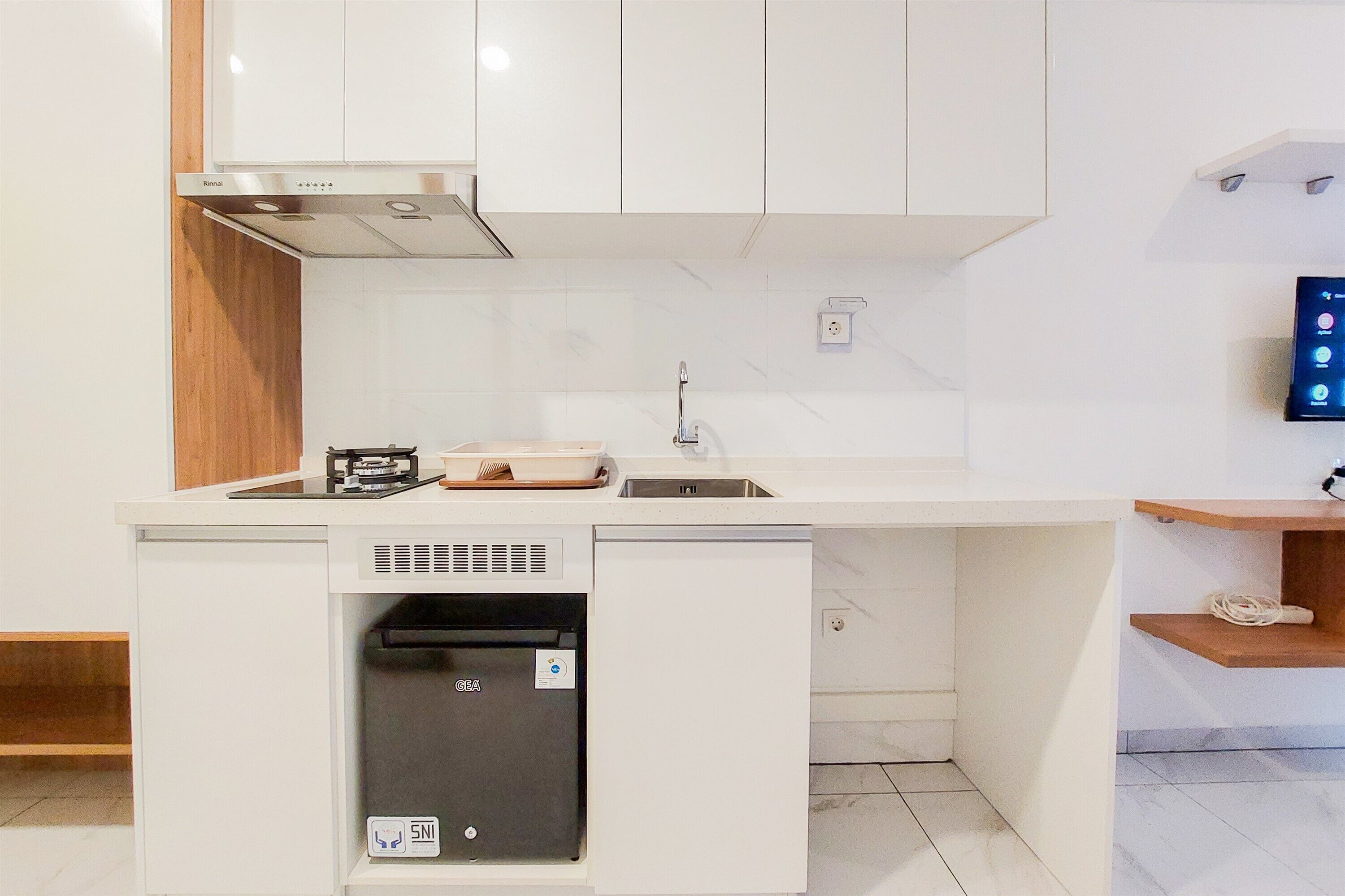 A compact kitchen with a built-in dishwasher, a microwave, and a sink.