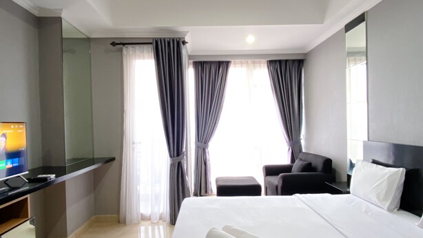 Une chambre d’hôtel équipée d’un lit, d’un bureau, d’une chaise et d’un téléviseur.