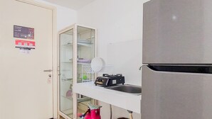A kitchen with a built-in microwave, a glass-fronted cabinet, and a stainless steel refrigerator. - Cozy Stay Studio Apartment At M-Town Residence (Gading Serpong)