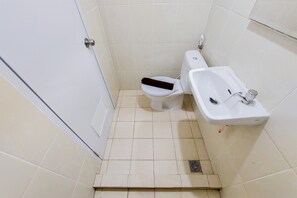 Un bagno piccolo con il water, un lavandino e una porta.