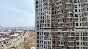 Un edificio residencial alto con varios balcones y vistas a la ciudad.