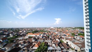 A densely packed urban area with a variety of building styles and a clear sky. - Simple And Tidy Studio Apartment At Suncity Residence (Sidoarjo)