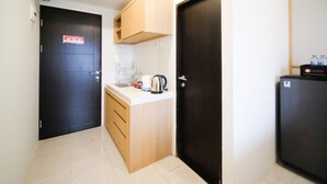 Cocina compacta con fregadero, hervidor y refrigerador.