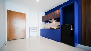 A modern kitchen with blue cabinets, a black refrigerator, and a white countertop. - Best Choice And Spacious 1Br Apartment At Aryaduta Residence Surabaya (Surabaya)