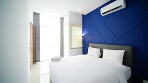 A hotel room with a bed, a window with curtains, an air conditioning unit, and a wall-mounted mirror. - Best Choice And Spacious 1Br Apartment At Aryaduta Residence Surabaya (Surabaya)