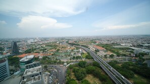 Panoramic city views from a high vantage point, with a major highway and a mix of residential and commercial buildings.