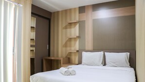 Una cama bien hecha con sábanas blancas y dos almohadas, una mesita de noche de madera y una pared con un diseño geométrico.