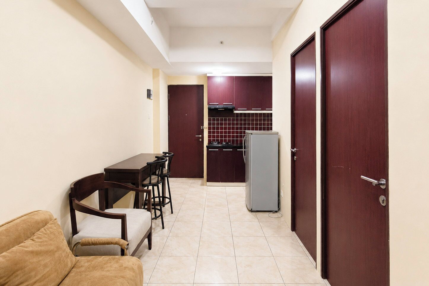 A compact living space with a dining area, kitchenette, and a sofa.