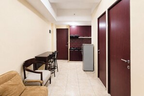 A compact living space with a dining area, kitchenette, and a sofa.