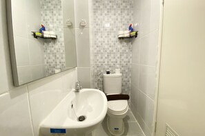 A bathroom with a white sink, toilet, and tiled walls. - Relaxing Studio At 19Th Floor Tokyo Riverside Pik 2 Apartment (Teluknaga)
