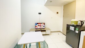 A small kitchenette with a refrigerator, a microwave, and a coffee maker. There is a small table and a chair in the foreground. - Comfortable 2Br At Tokyo Riverside Pik 2 Apartment (Teluknaga)