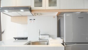 A modern kitchen with a stainless steel refrigerator, a built-in oven, and a sink with a faucet. - Comfort And Enjoy Living Studio Casa De Parco Apartment (Pagedangan)