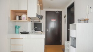A compact kitchen with a coffee maker, kettle, and a water dispenser. - Comfort And Enjoy Living Studio Casa De Parco Apartment (Pagedangan)