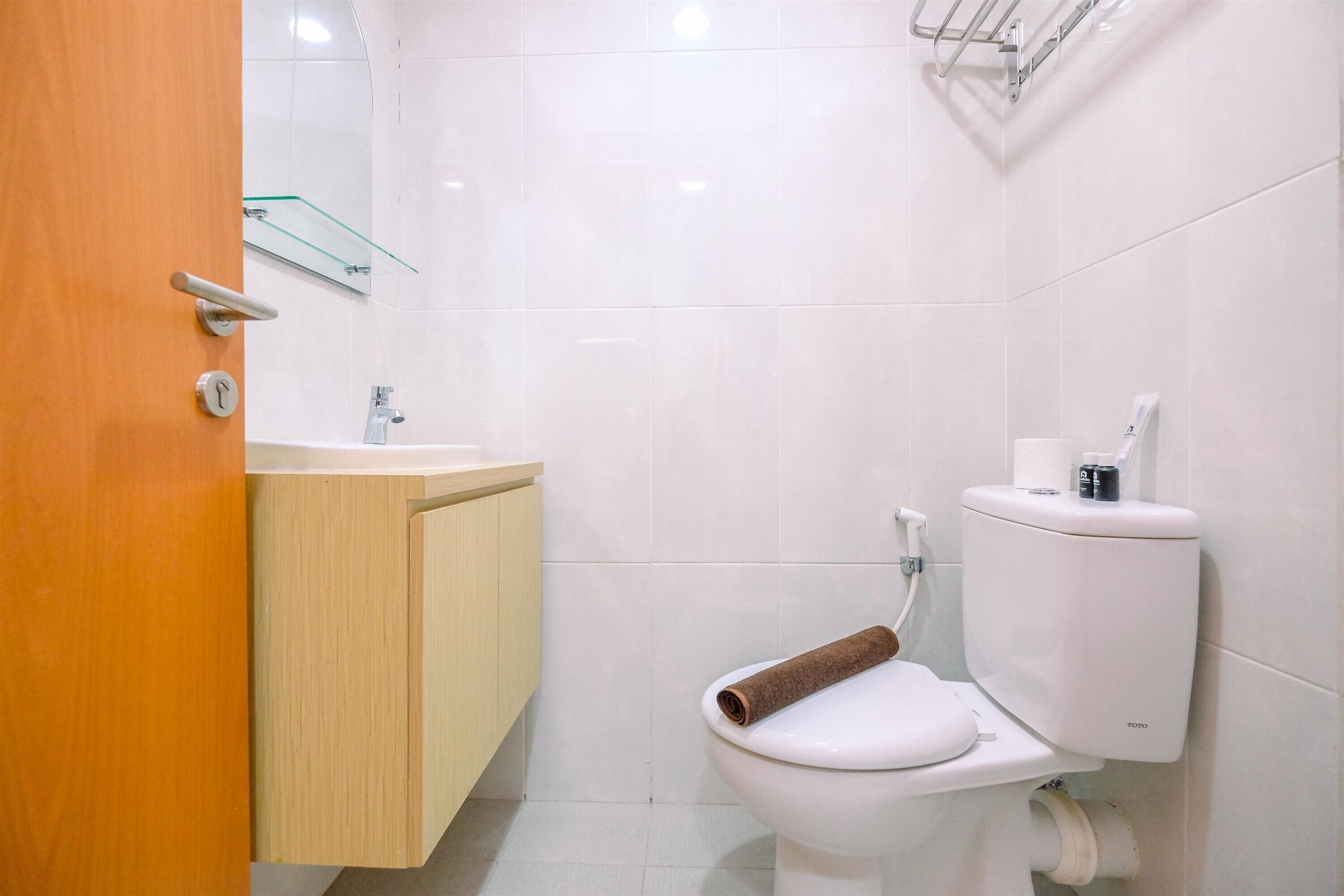 A modern bathroom with a toilet, sink, and mirror.